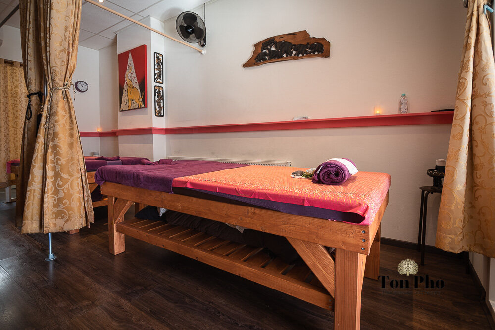 Lichte behandelkamer met houten massagetafel
