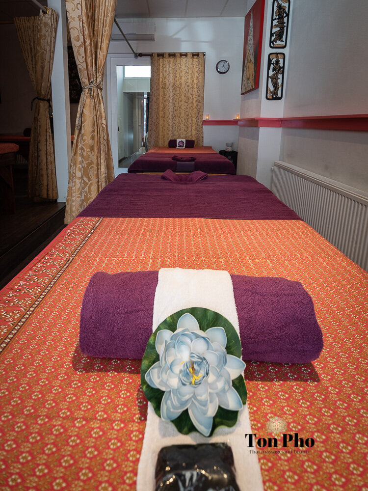 Opgerolde handdoek met lotusbloem op een Thaise massagemat